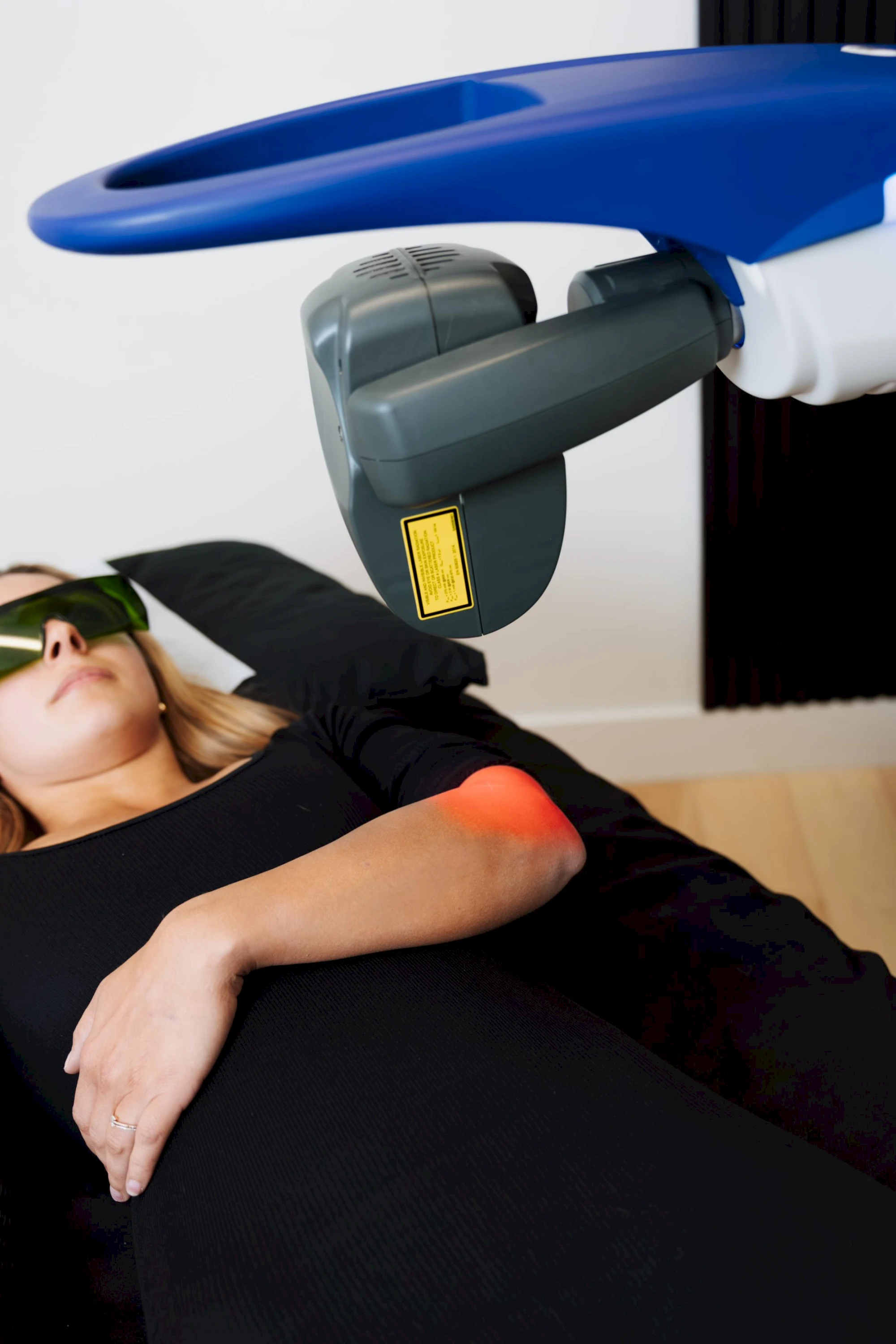 Therapist positioning an MLS laser therapy device over a client's leg