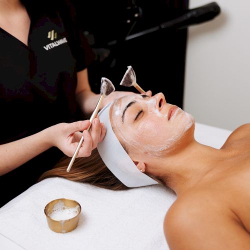 A person is helping someone else with a manicure or applying nail polish on fingernails.