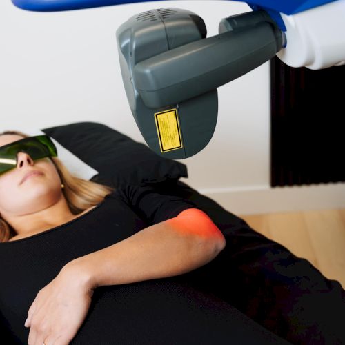 A man lies on a couch while a blue vacuum cleaner head hovers over him, as if about to clean or probe him, image ends abruptly.